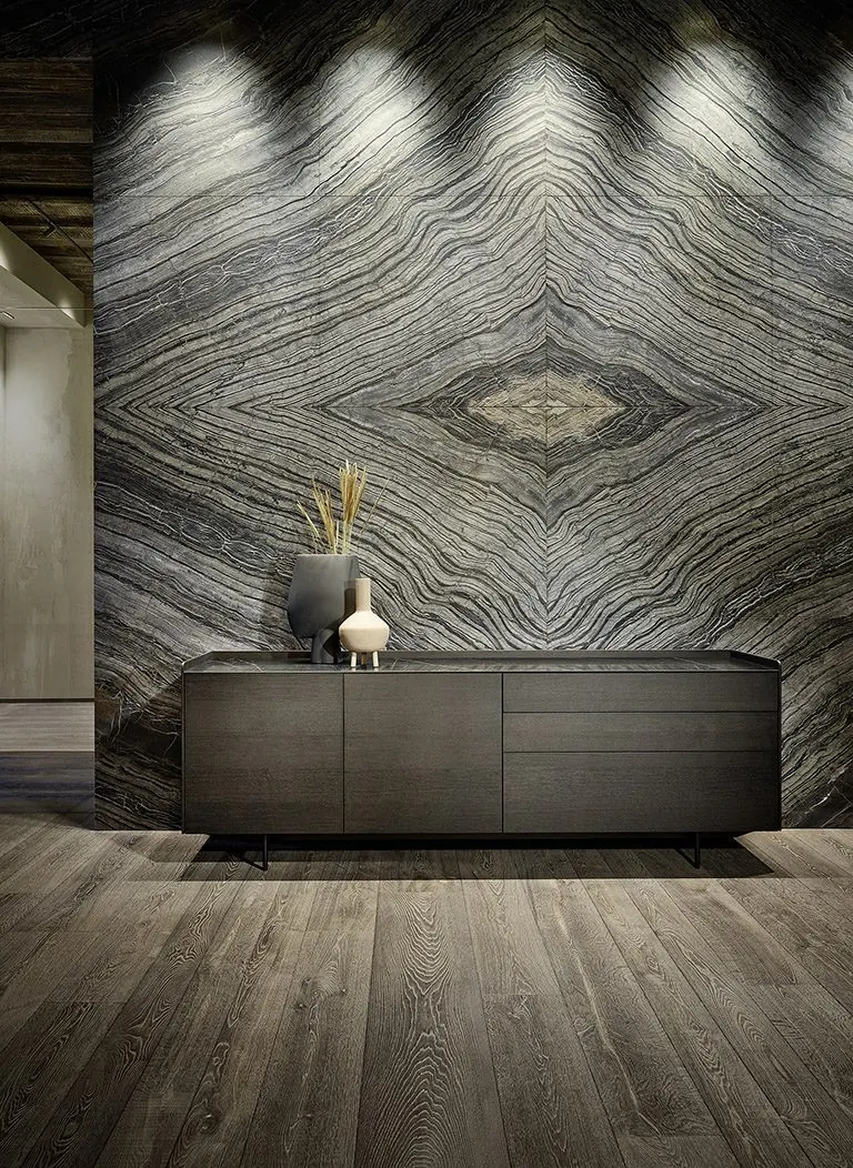 Sideboard aus dunklem Holz vor einer großformatig marmorierten Wand