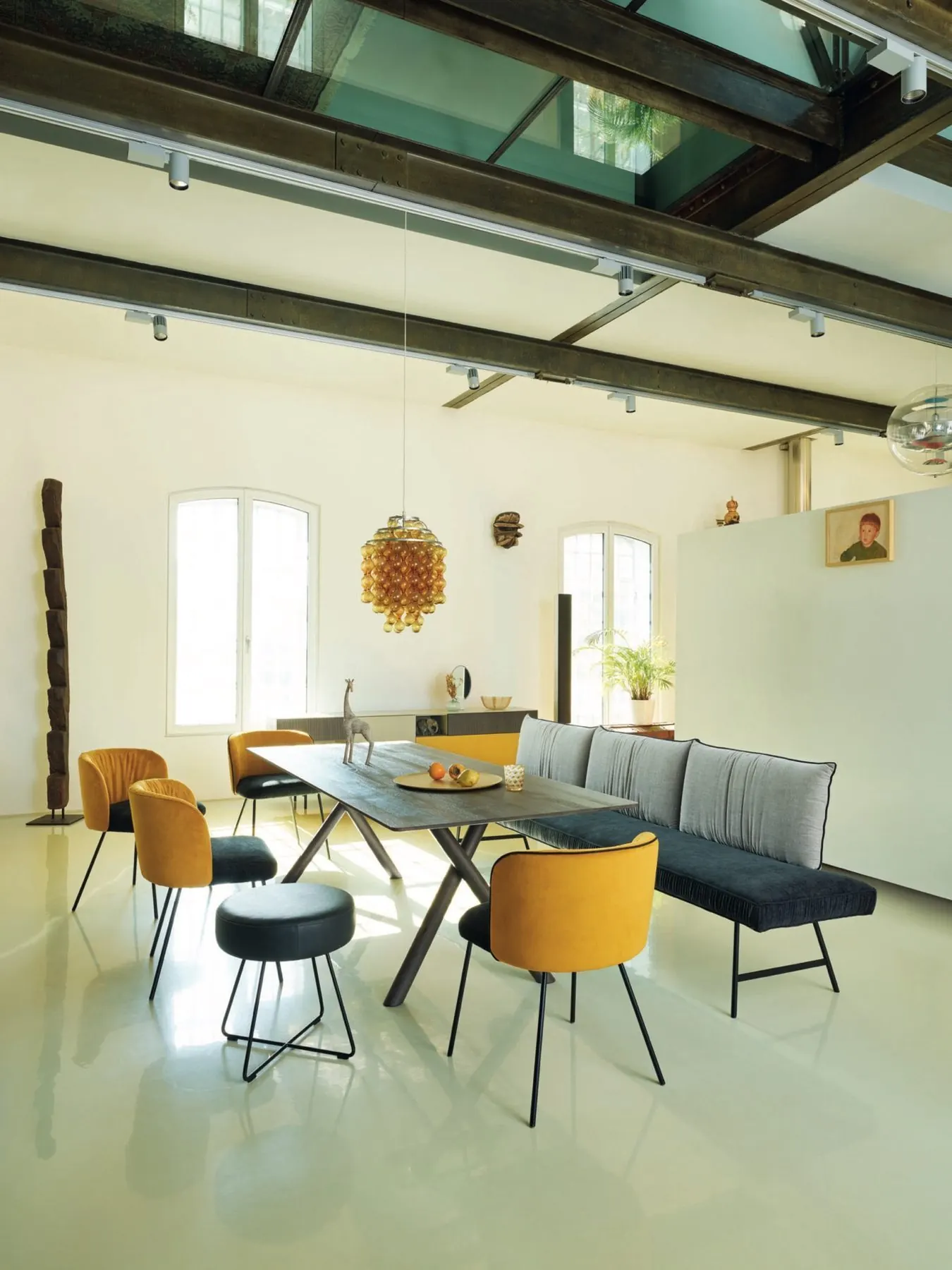 Essplatz mit gelben Polsterstühlen und dunkler Sitzbank im Loft