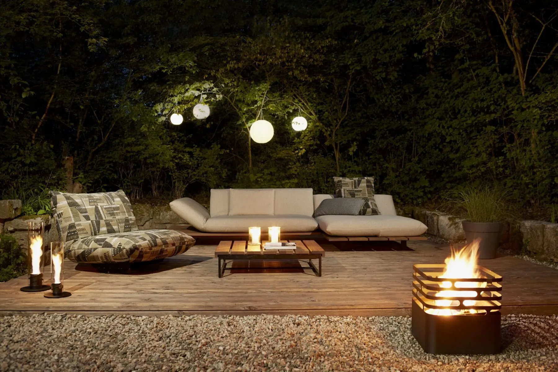 Outdoor-Lounge Akito am Abend mit Feuerschale und Lichterketten