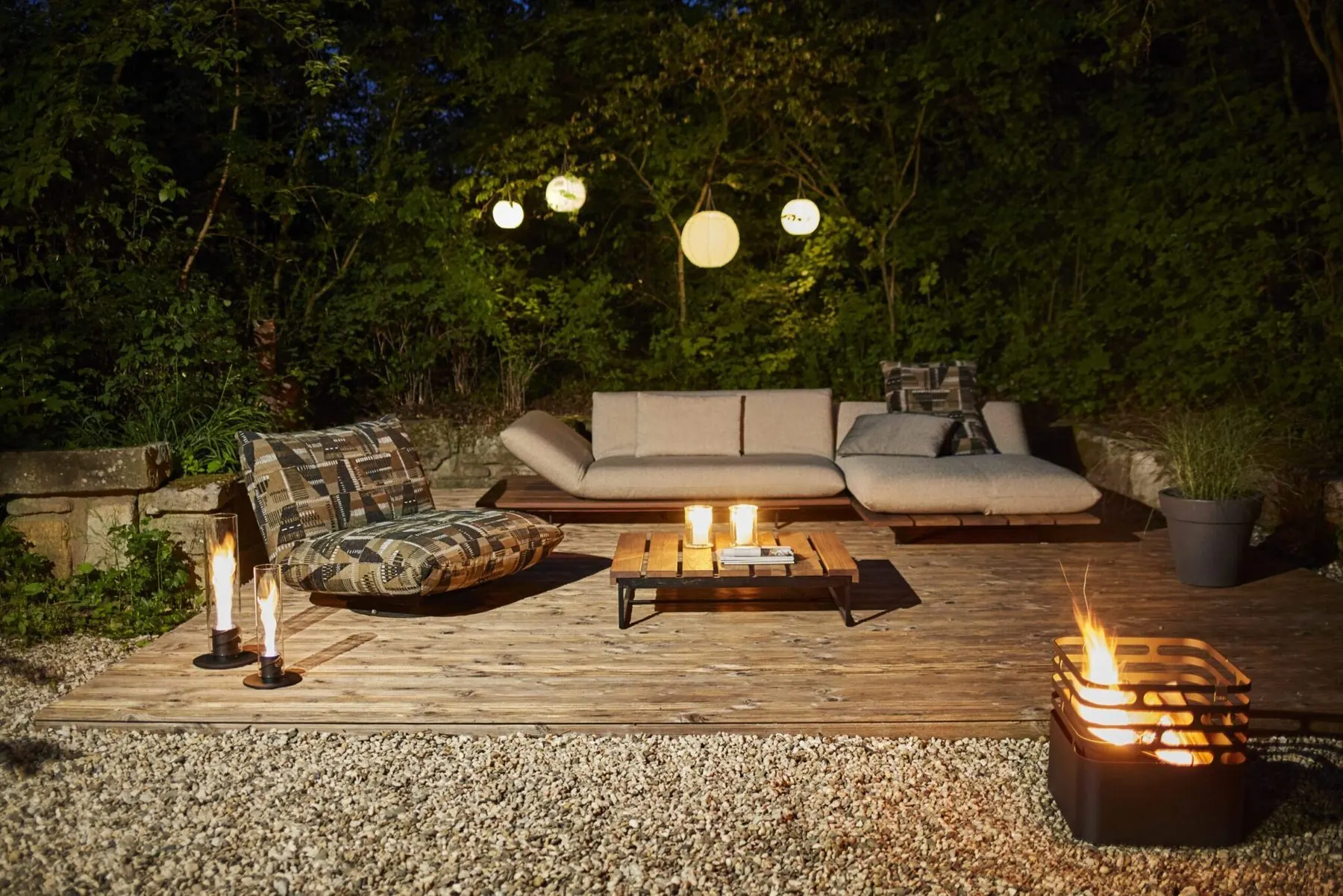 Outdoor-Lounge Akito auf einer Holzterrasse mit brennender Feuerstelle