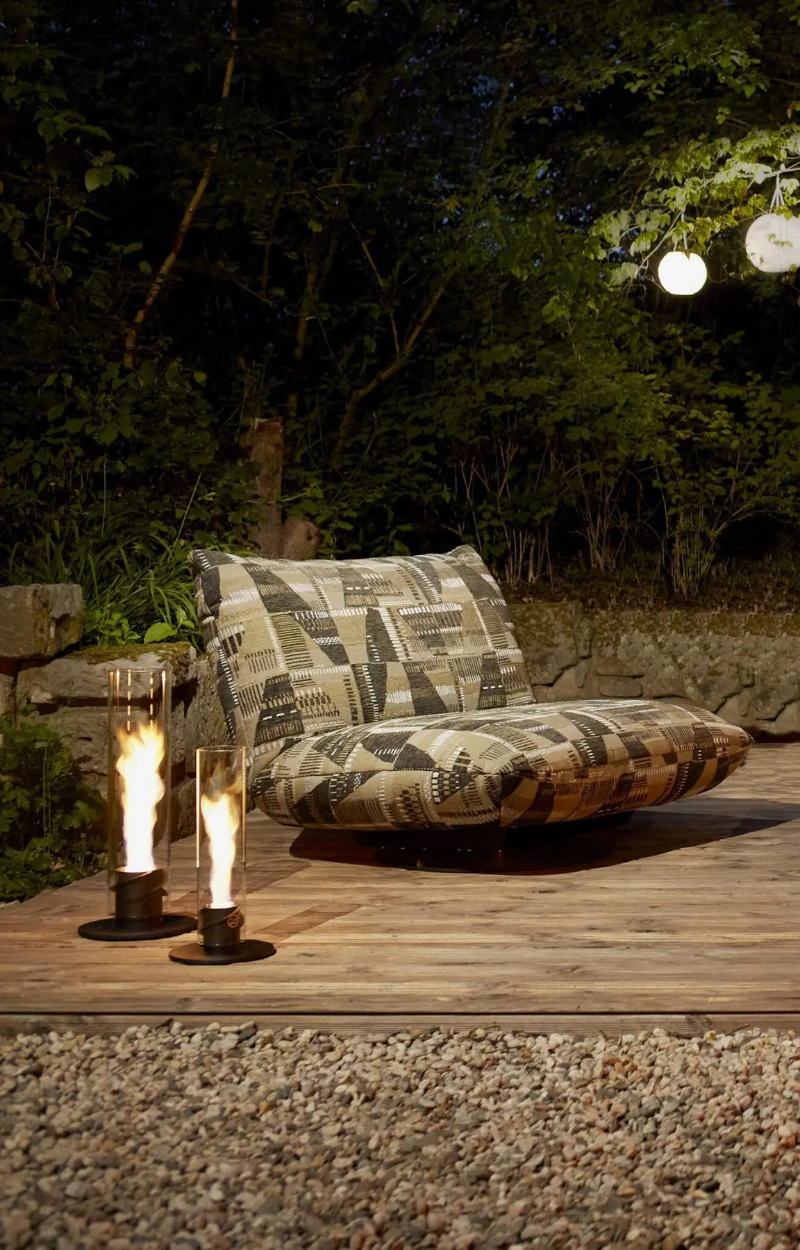 Outdoor-Sessel Boogie am Abend im Garten neben Windlichtern