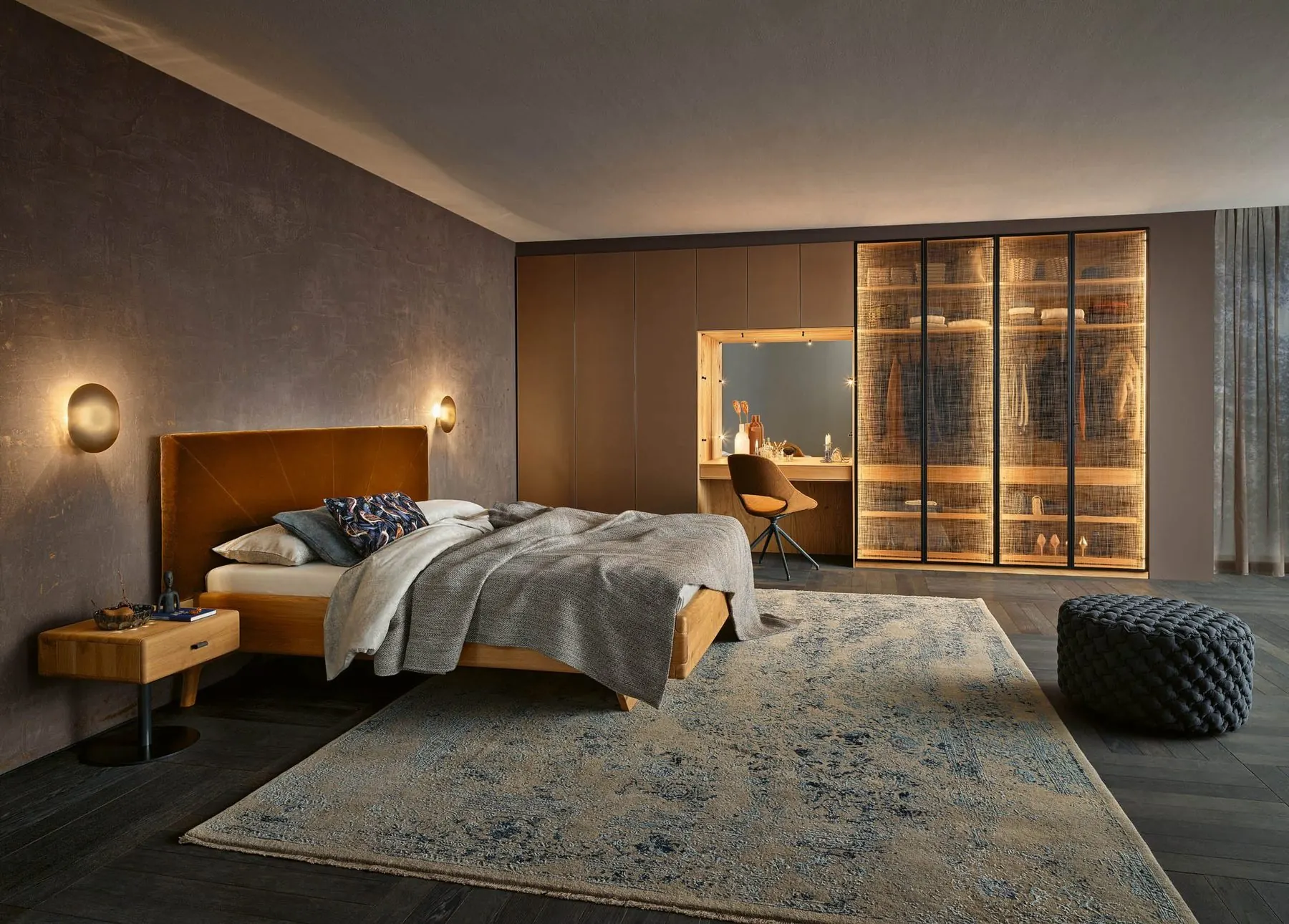 Schlafzimmer mit Bett, Schrankwand und beleuchtetem Schminkplatz
