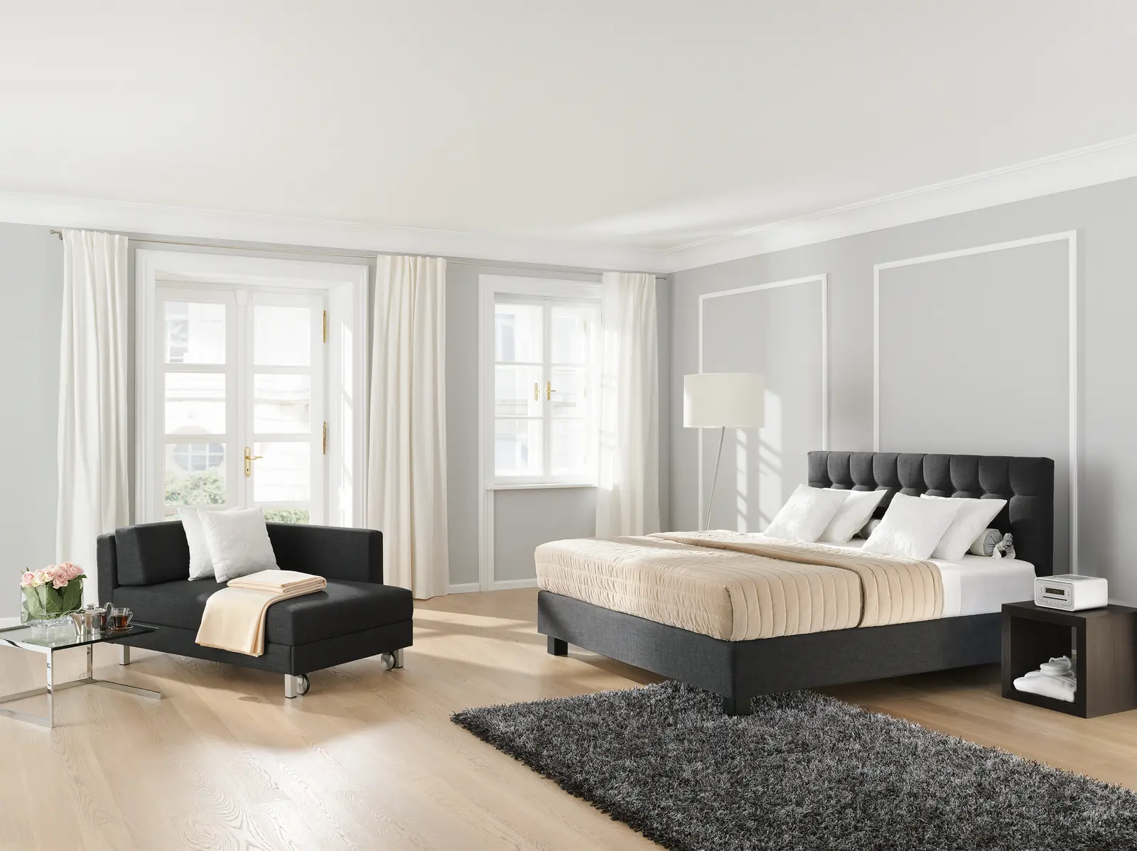 Graues Boxspringbett Noblesse mit Kopfteil und Chaiselongue im Schlafzimmer