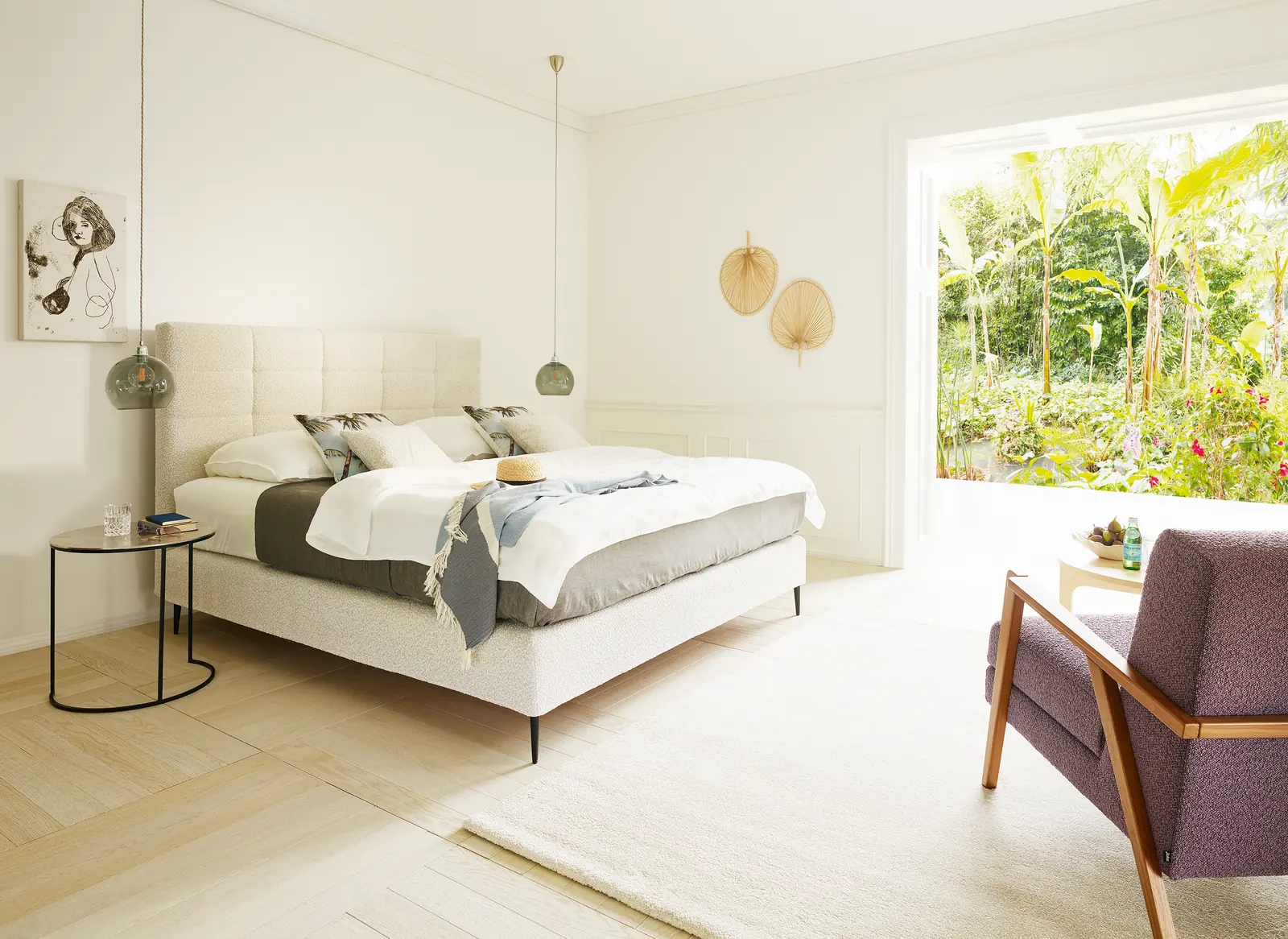 Boxspringbett Mattina mit weißem Bettzeug vor einer Fensterfront mit Gartenblick