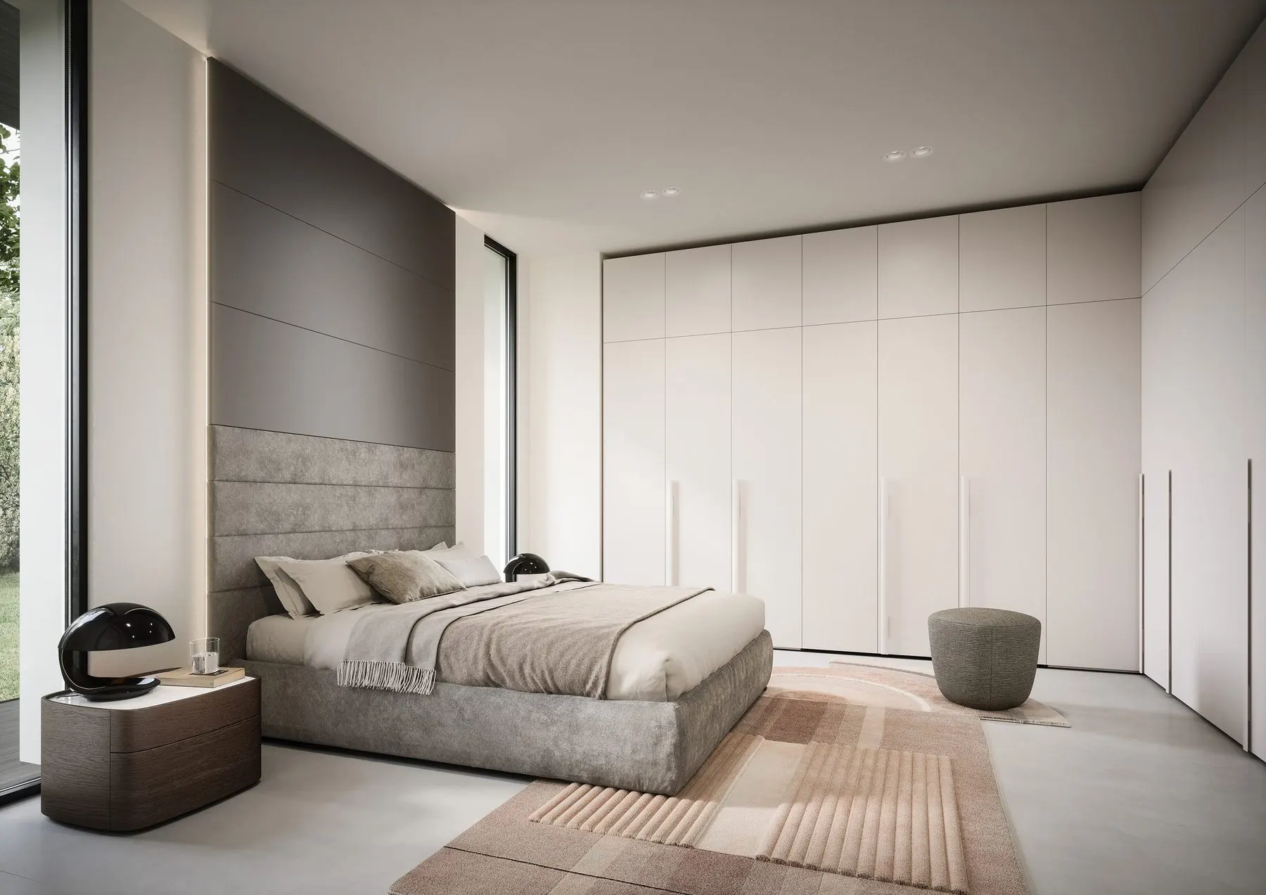Schlafzimmer mit Bett vor einem raumhohen weißen Wandverbau