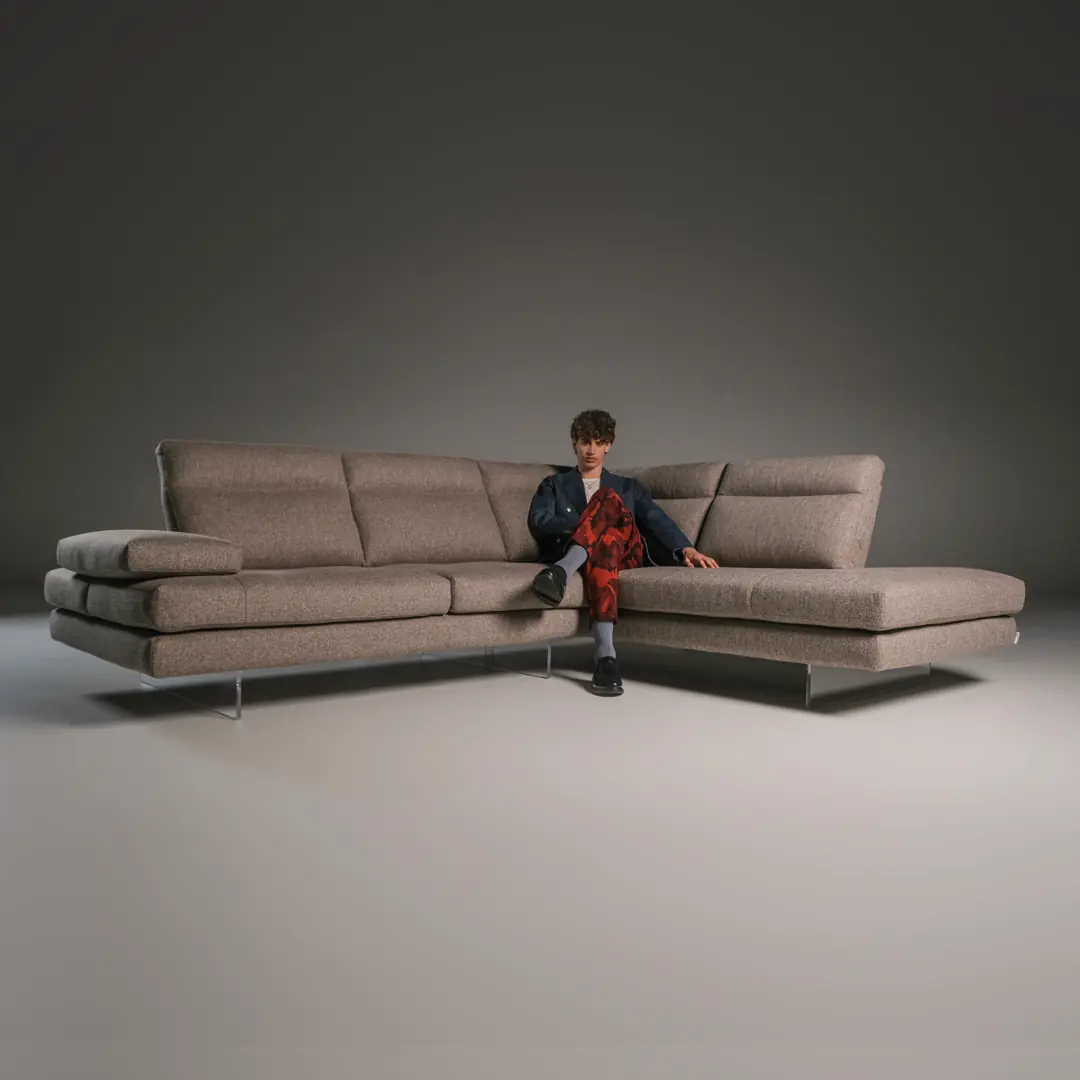Graues Ecksofa Toby Wing mit einer sitzenden Person