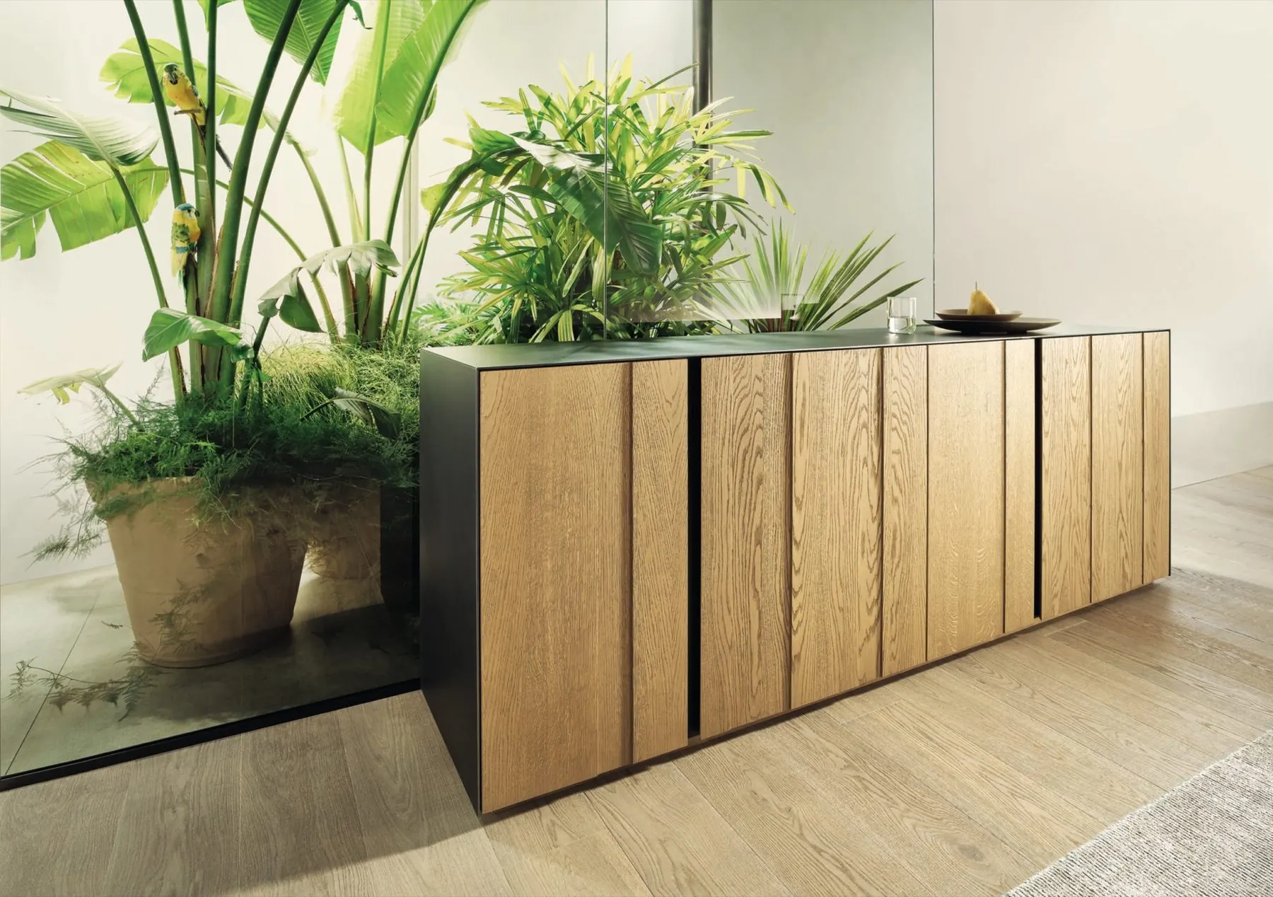 Sideboard aus Eiche vor großen Grünpflanzen