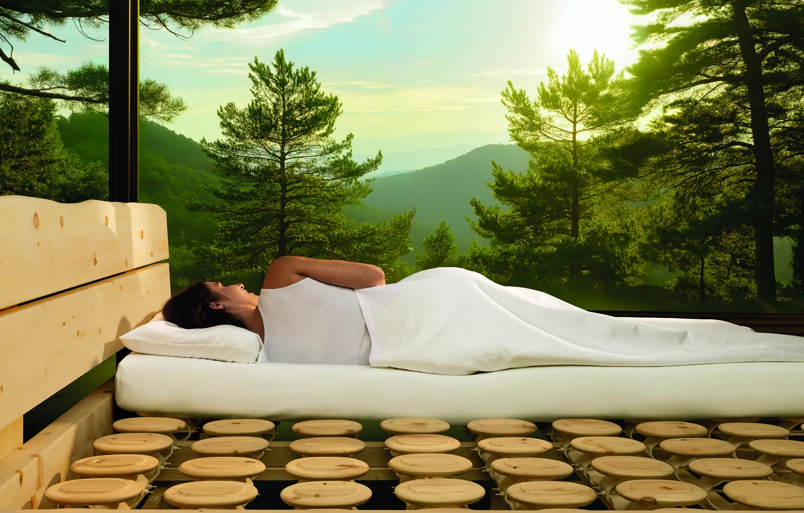 Person in Seitenlage auf dem Relax-2000-Schlafsystem mit sichtbaren Holztellern im Zirbenbett